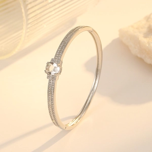 Vintage emerald zircon open bangle with sparkling pave accents on a warm neutral background