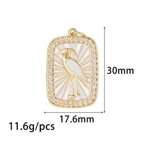 Detail view of a gold tarot pendant with white enamel crane and shimmering rhinestones