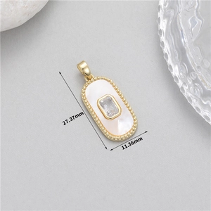 Detail view of oval gold pendant with white shell inlay and zircon measuring 27.37mm