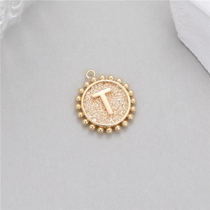 14K gold circular coin pendant with letter T featuring a hammer texture and beaded edge
