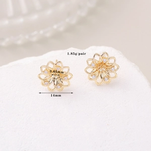 Elegant gold clover earrings with micro-set zircons on a white textured stone base
