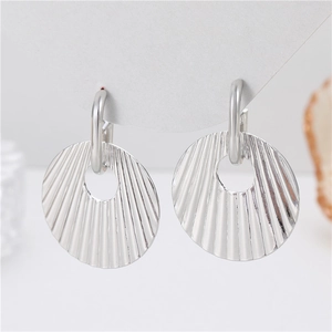 Boucles d'oreilles argentées style chip avec texture radiale sur carte blanche