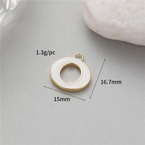 Macro detail of 15mm gold round pendant with white enamel inlay and size labels