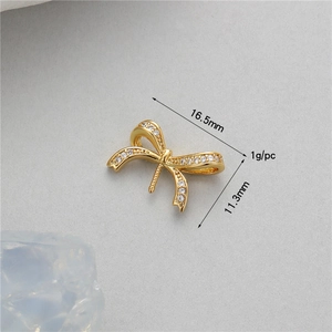 Macro shot of 16.5mm gold bow jewelry charm with cubic zirconia for DIY accessory