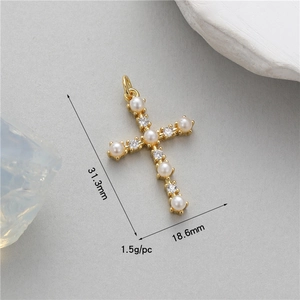 Macro shot of gold cross pendant with white pearls and zircons measuring 31.3x18.6mm