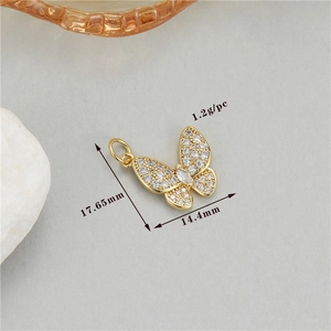 Macro shot of 1.2g butterfly pendant with sparkling cubic zirconia on light gray background