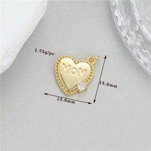 Détail macro d'un pendentif cœur doré avec gravure MOM et petite pierre de zircon