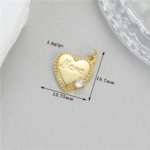 Détail d'un pendentif cœur doré avec gravure Mama et petite incrustation de zircon