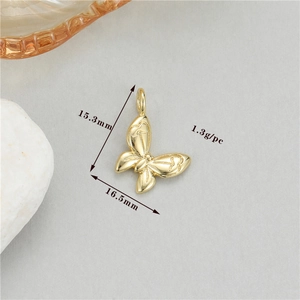 Golden butterfly pendant detail showing dimensions 15.3x16.5mm and engraved heart texture