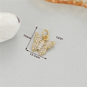 Detailed macro view of 16mm gold butterfly pendant with cubic zirconia measurements