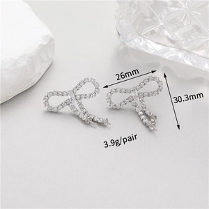 Detailed macro view showing bow earring dimensions 26mm x 30.3mm with zircon inlay