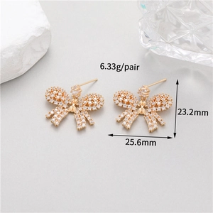 Detail of gold bow earrings with clear zircons, 6.33g weight and 25.6mm width