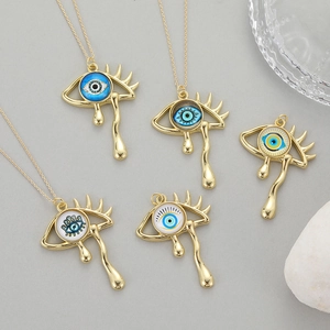 Vintage goldene Tränendes Auge Halskette mit Wimpern und Tränendetails auf grauem Untergrund