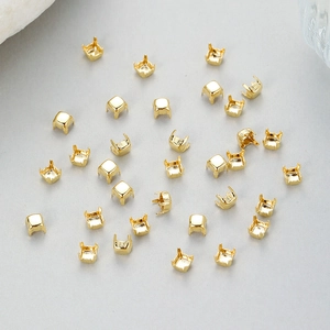Macro view of scattered gold-plated square four-claw brass settings for DIY jewelry making
