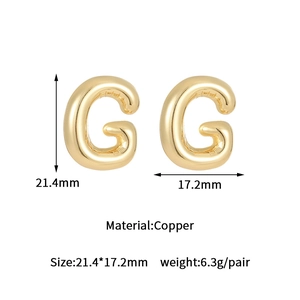 Detailed view of gold G letter bubble earrings with size and copper material specs