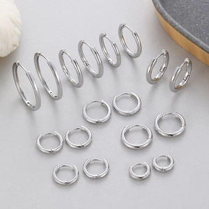 Polished silver hoop earrings set with multiple sizes displayed on minimalist tray