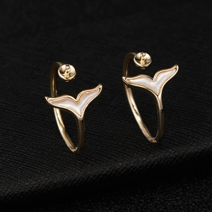 Macro shot of 14K gold plated fishtail earrings with white inlay and pearl settings