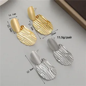 Vue détaillée de boucles d'oreilles pendantes mates dorées et argentées avec dimensions