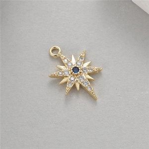 Detailed view of a gold polar star pendant with blue gemstone and zircon inlay