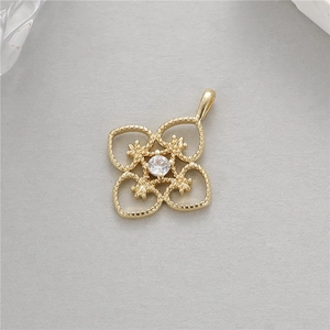 Detailed view of a gold clover pendant with milgrain edges and a sparkling center zircon