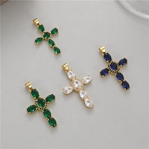 Detail view of cross pendants with emerald, blue, and clear cubic zirconia in gold plating