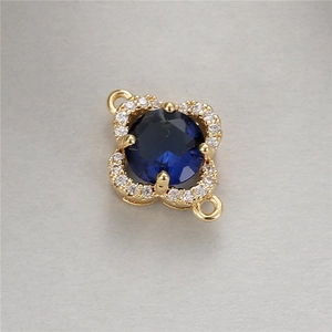 Detail of four-leaf clover pendant with blue sapphire-like stone and white zircons
