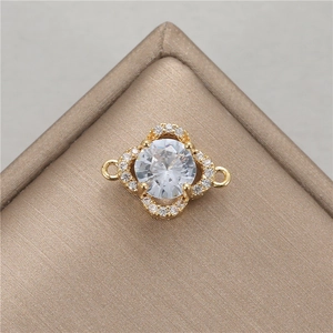 Macro detail of a gold clover charm connector with cubic zirconia for DIY jewelry making