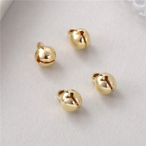 Makro-Detail von vier polierten 14K vergoldeten Kupferglocken für DIY-Schmuck