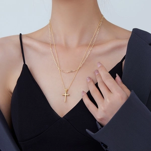 Double-layer golden necklace with cross pendant on model for hip-hop streetwear style