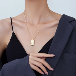Golden tarot card pendant necklace featuring vintage embossed details on a chic chain