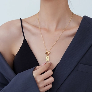 Vintage gold OT buckle necklace featuring a rectangular moon pendant on professional model