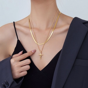 Double-layered golden snake chain necklace with cross pendant for a stylish bohemian look