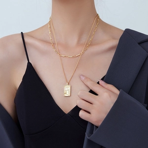 Double layered gold necklace with rectangular tarot pendant and paperclip chain
