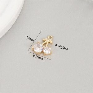 Macro detail of cherry-shaped gold pendant with cubic zirconia, 13mm size for jewelry DIY