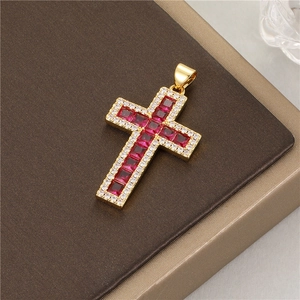 Close-up of 14K gold cross pendant with red gemstones and zircon halo on leather