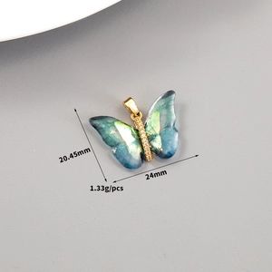 Macro shot showing dimensions of a 14K gold butterfly pendant with blue shell wings