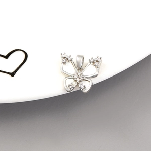 Detailed close-up of bow-shaped shell pendant with 14K gold plating and cubic zirconia
