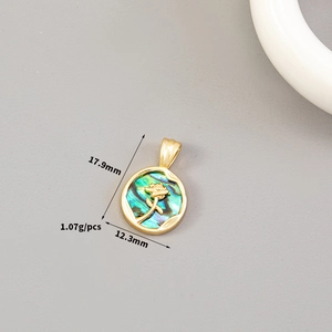Detailed view of a 14K gold-plated round pendant with green shell inlay and rose relief