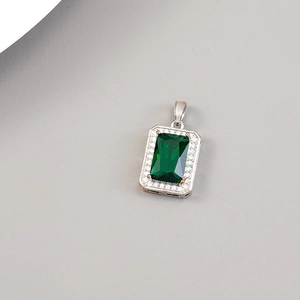 Dettaglio del ciondolo con pietra verde taglio smeraldo e cornice di piccoli zirconi