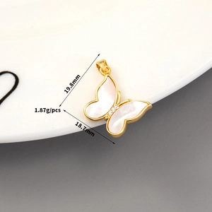Macro shot of butterfly pendant with 14K gold frame, shell wings and zircon details