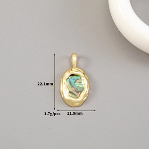 Detailed macro view of 14K gold hammered oval pendant with iridescent shell inlay