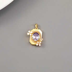 Dettaglio di un ciondolo vintage in oro con gemma viola, perle e fiori in smalto bianco