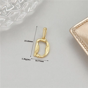 Nahaufnahme von goldenem Feder-Anhänger Buchstabe D mit Maßen 23,26mm mal 10,77mm