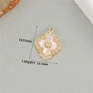 Detailed view of 14K gold floral pendant with white mother-of-pearl and zircon inlays