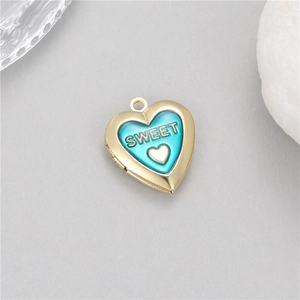 Macro detail of 14K gold plated heart locket with blue enamel and Sweet engraving