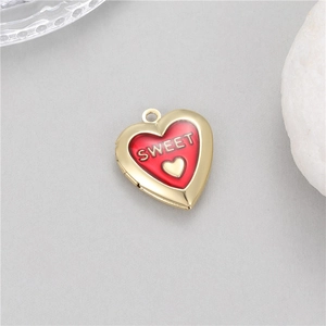 Macro shot of 14K gold plated heart locket pendant with red enamel and Sweet text