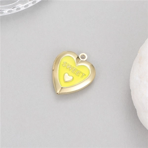 Detail of a 14K gold-plated heart locket with yellow enamel and SWEET engraving