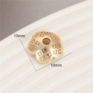 Macro shot of 10mm gold flower bead cap with square grid texture for DIY jewelry making