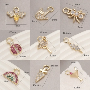 Detailed view of nine gold micro-pave cubic zirconia charms with assorted unique designs