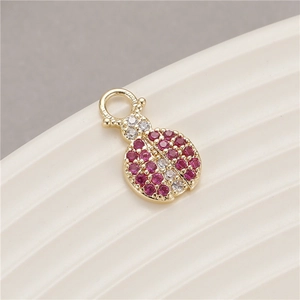 Detailed macro view of ladybug-shaped pendant with red and white zircons in gold setting